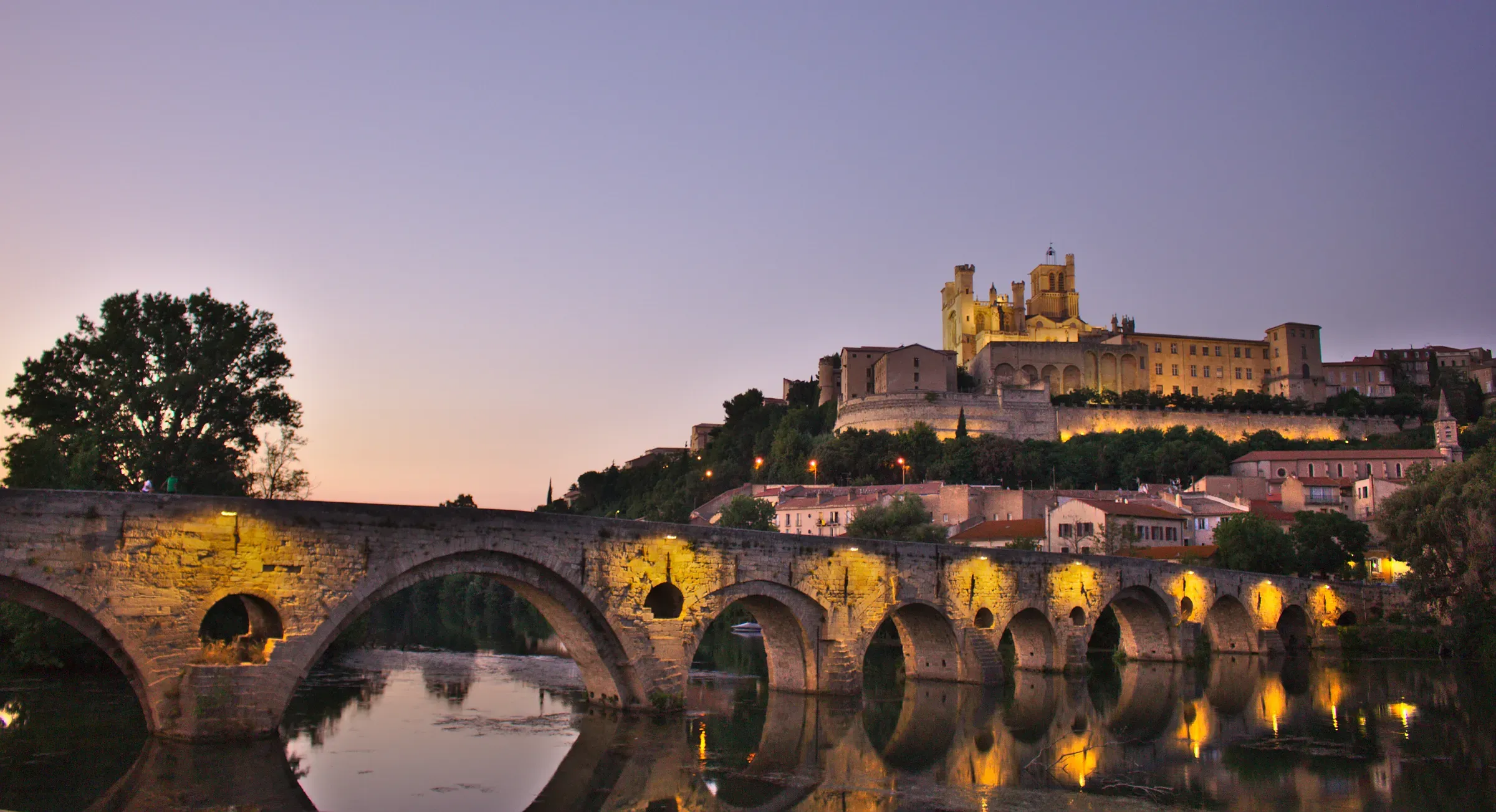 Béziers at dusk: Saint-Nazaire Cathedral above the Pont Vieux and the river Orb.